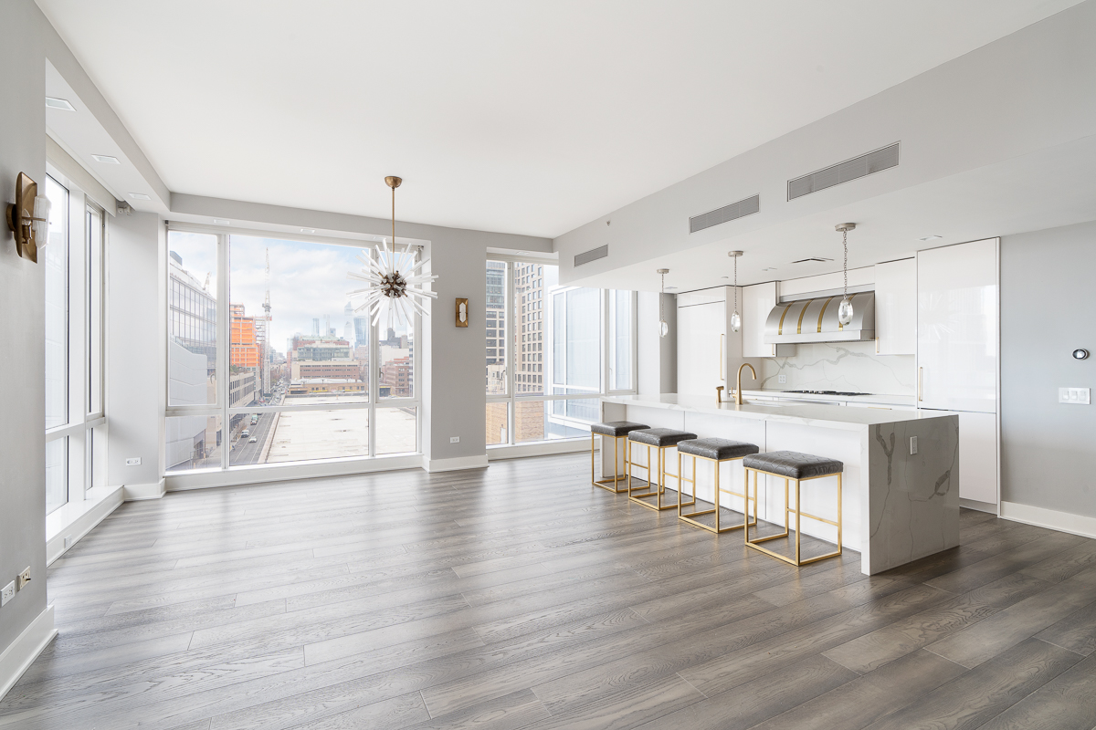 330 Spring Street, Unit 8B Manhattan, NY 10013 - Photo 9 of 14 a large living room with stainless steel appliances wooden floors and white walls