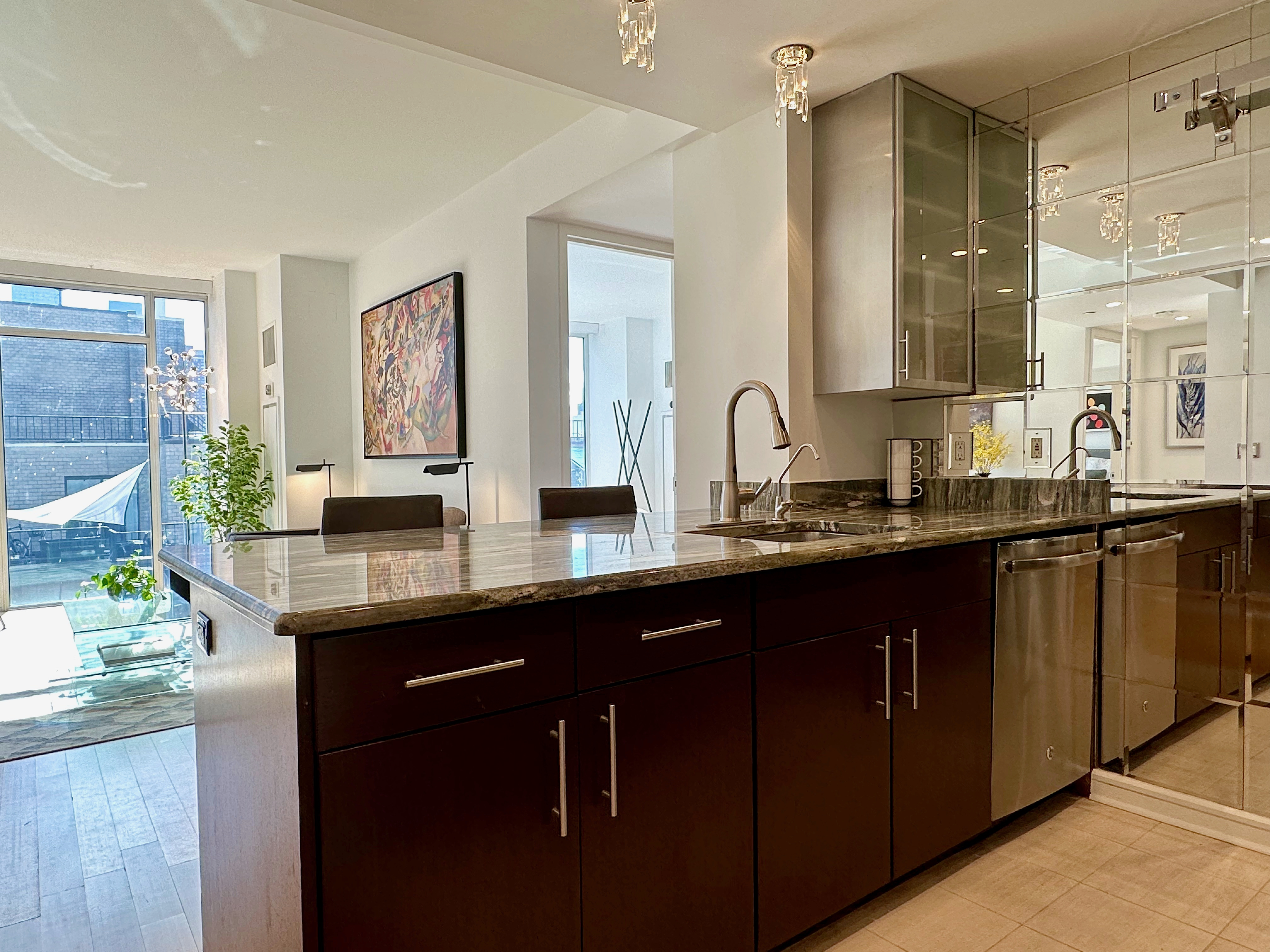 350 West 53rd Street, Unit PHA Manhattan, NY 10019 - Photo 9 of 35 a kitchen with a sink and a wooden cabinets
