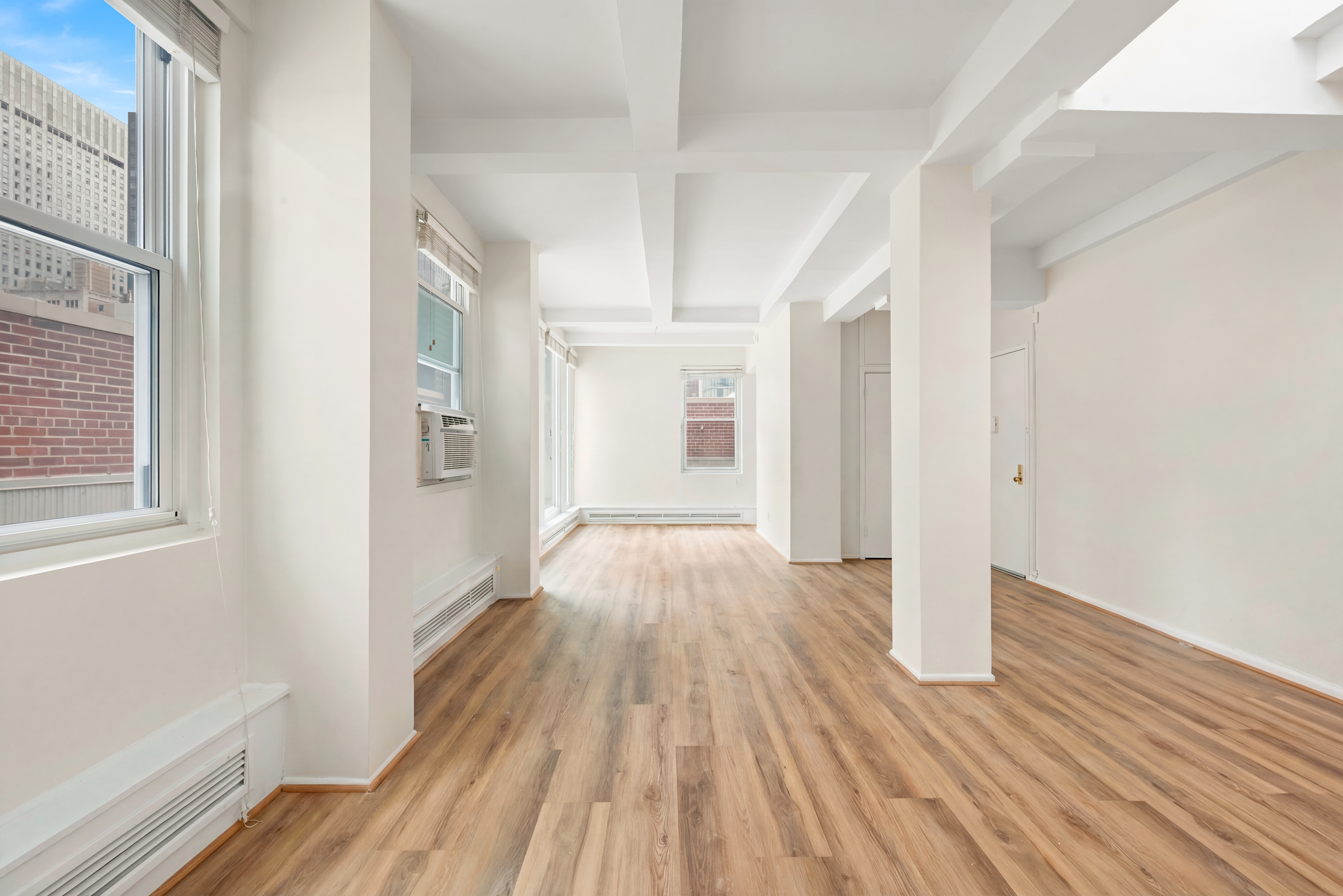 77 Park Avenue, Unit 16G Manhattan, NY 10016 - Photo 3 of 8 a view of an empty room with wooden floor and a window