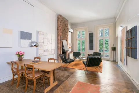 a living room with furniture a large window and wooden floor