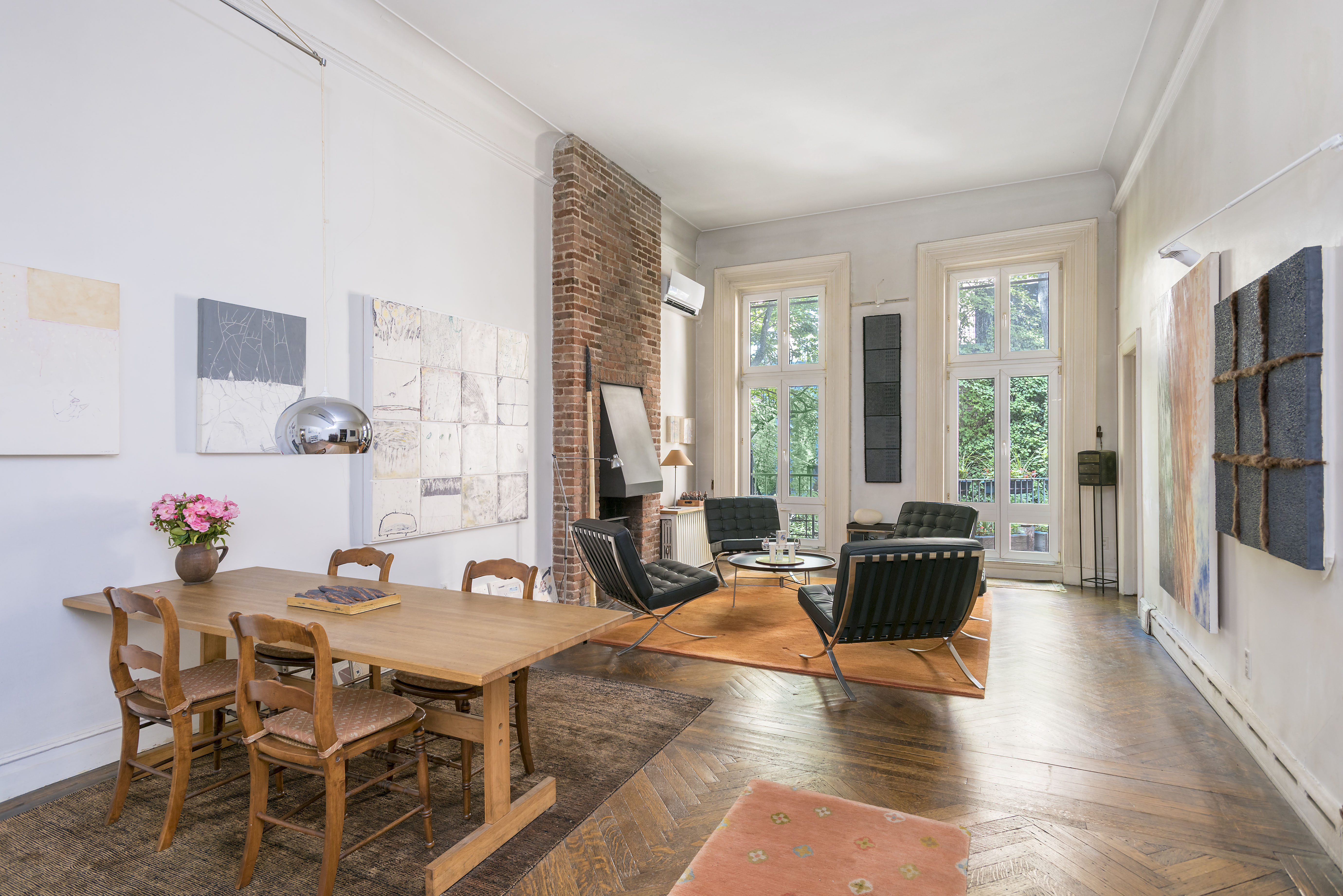 127 West 12th Street Manhattan, NY 10011 - Photo 3 of 8 a living room with furniture a large window and wooden floor