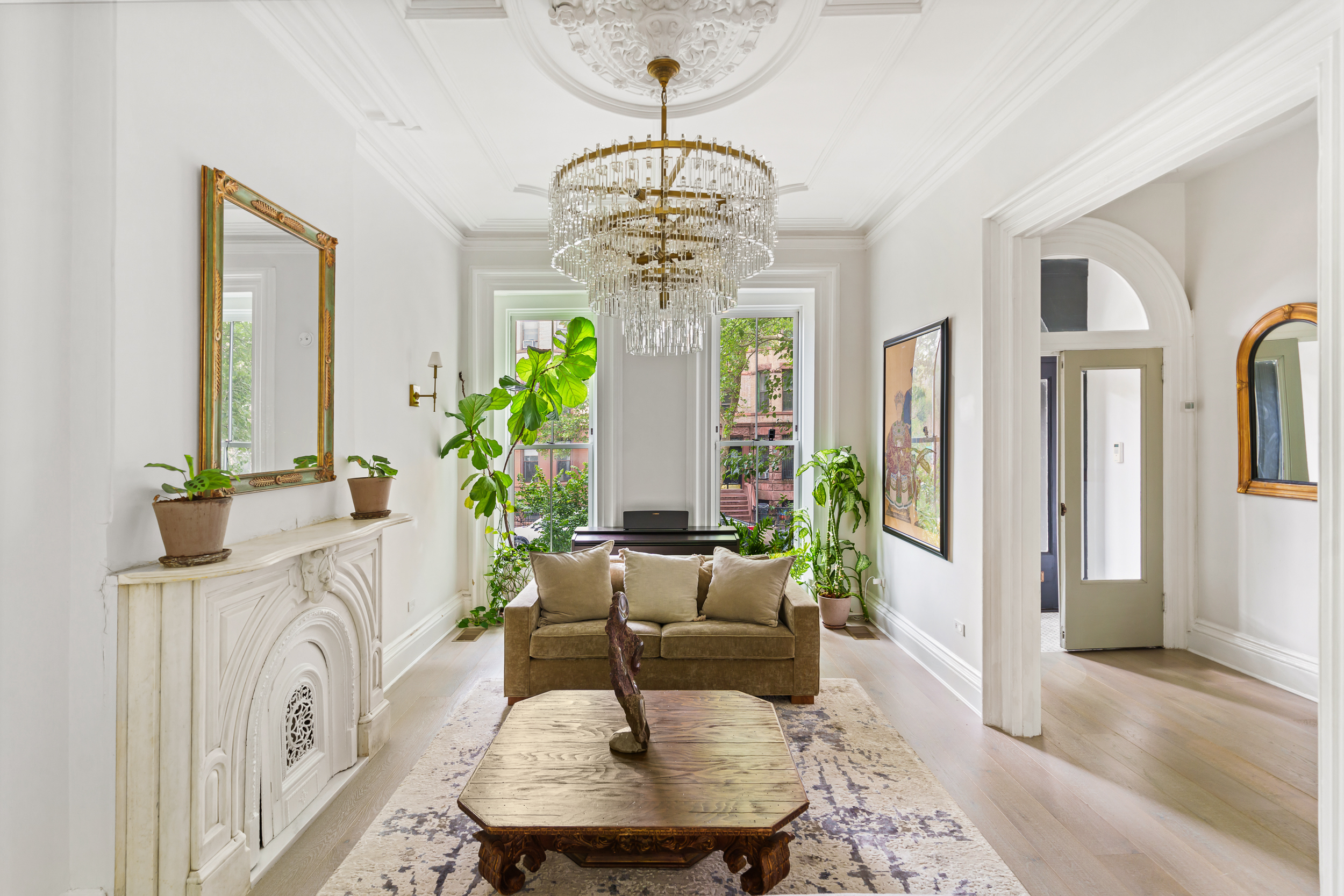 a living room with furniture a fireplace and a chandelier