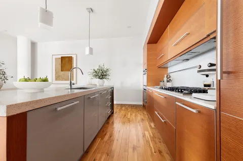 a kitchen with stainless steel appliances granite countertop a sink a stove and a wooden floors