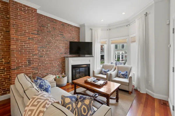 a living room with furniture a flat screen tv and a fireplace