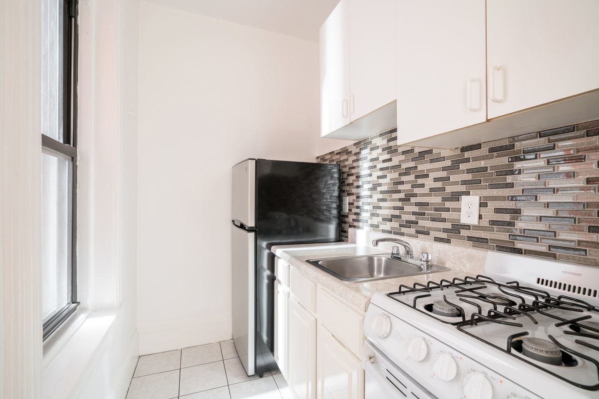 212 West 14th Street, Unit 3B Manhattan, NY 10011 - Photo 4 of 6 a kitchen that has a sink and a stove