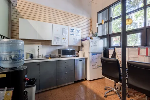 a kitchen with a table chairs refrigerator and cabinets