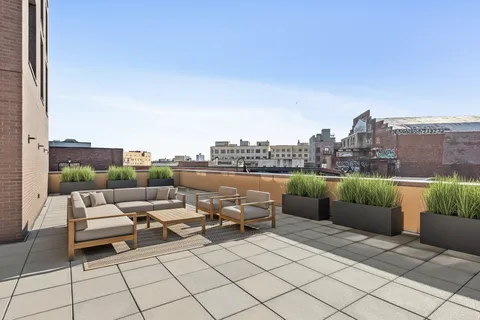 a terrace with outdoor seating and barbeque oven