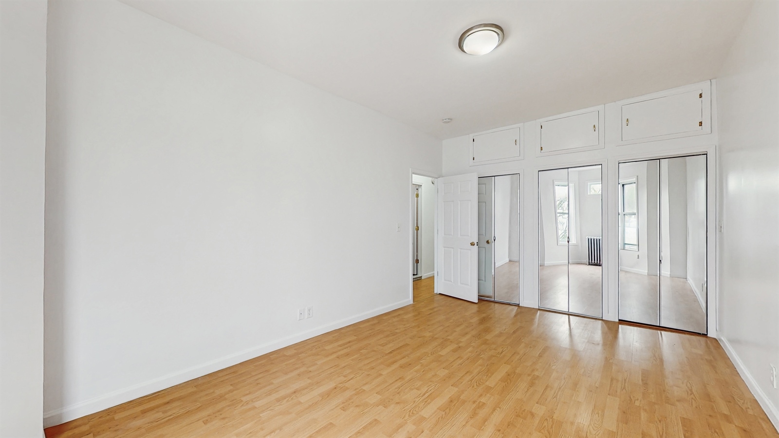 454 77th Street, Unit 3 Brooklyn, NY 11209 - Photo 22 of 25 a view of a room with wooden floor and white walls