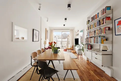 a view of a dining room with furniture and a book shelf