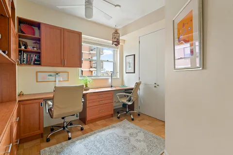 a view of a workspace with furniture and a window