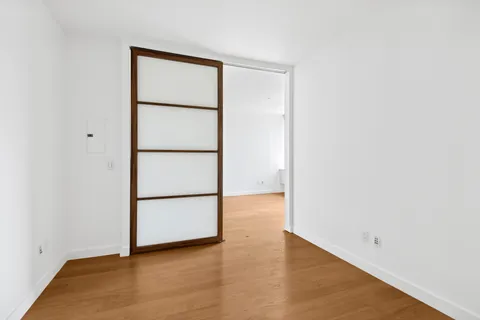 a view of an empty room with wooden floor