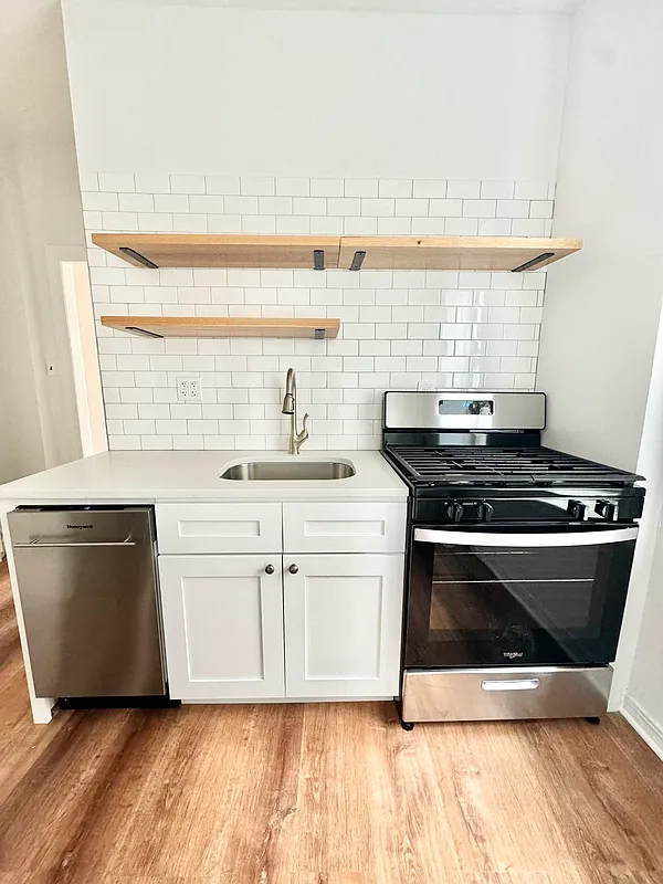 a kitchen with a stove and white cabinets