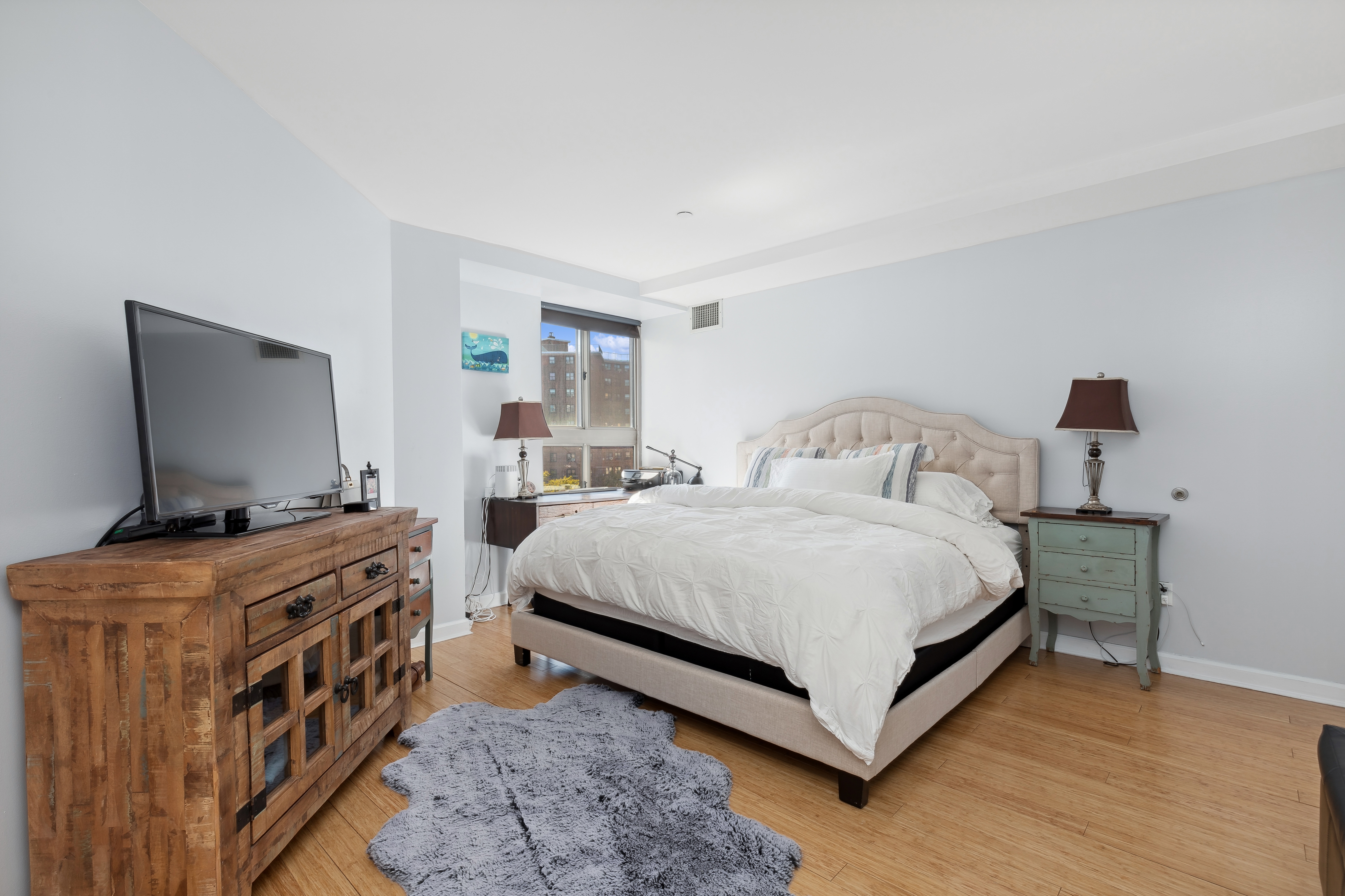 1400 5th Avenue, Unit 8J Manhattan, NY 10026 - Photo 5 of 10 a bedroom with a bed and flat screen tv