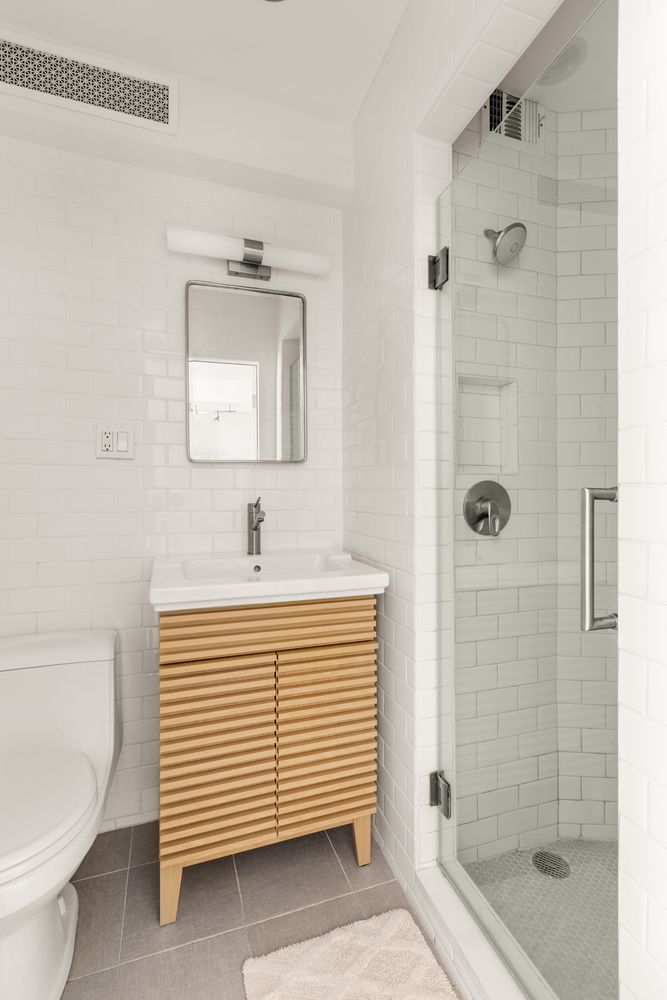 342 East 53rd Street, Unit 1G Manhattan, NY 10022 - Photo 4 of 9 a bathroom with a sink a toilet and shower