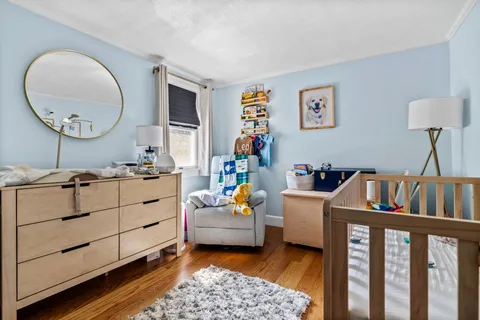 a living room with furniture and a baby crib