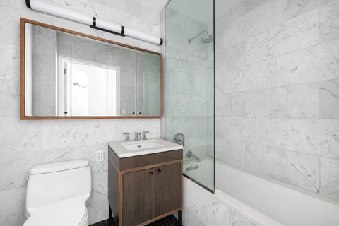 a bathroom with a sink a toilet and shower