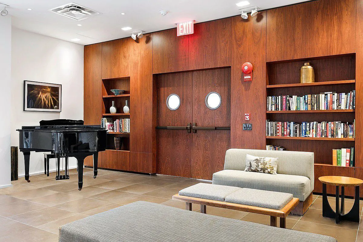 515 East 72nd Street, Unit 9J Manhattan, NY 10021 - Photo 13 of 17 a living room with furniture a projector and a bookshelf