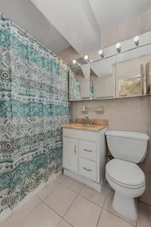 a bathroom with a granite countertop toilet and a sink