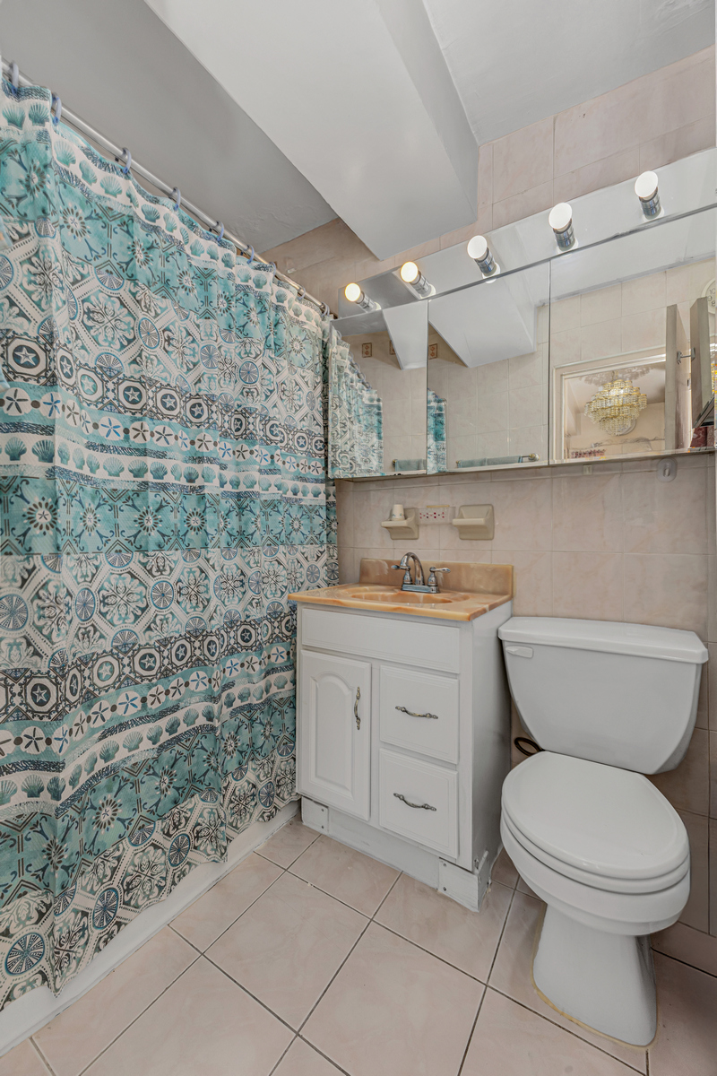 135 Ashland Place, Unit 8B Brooklyn, NY 11201 - Photo 10 of 11 a bathroom with a granite countertop toilet and a sink