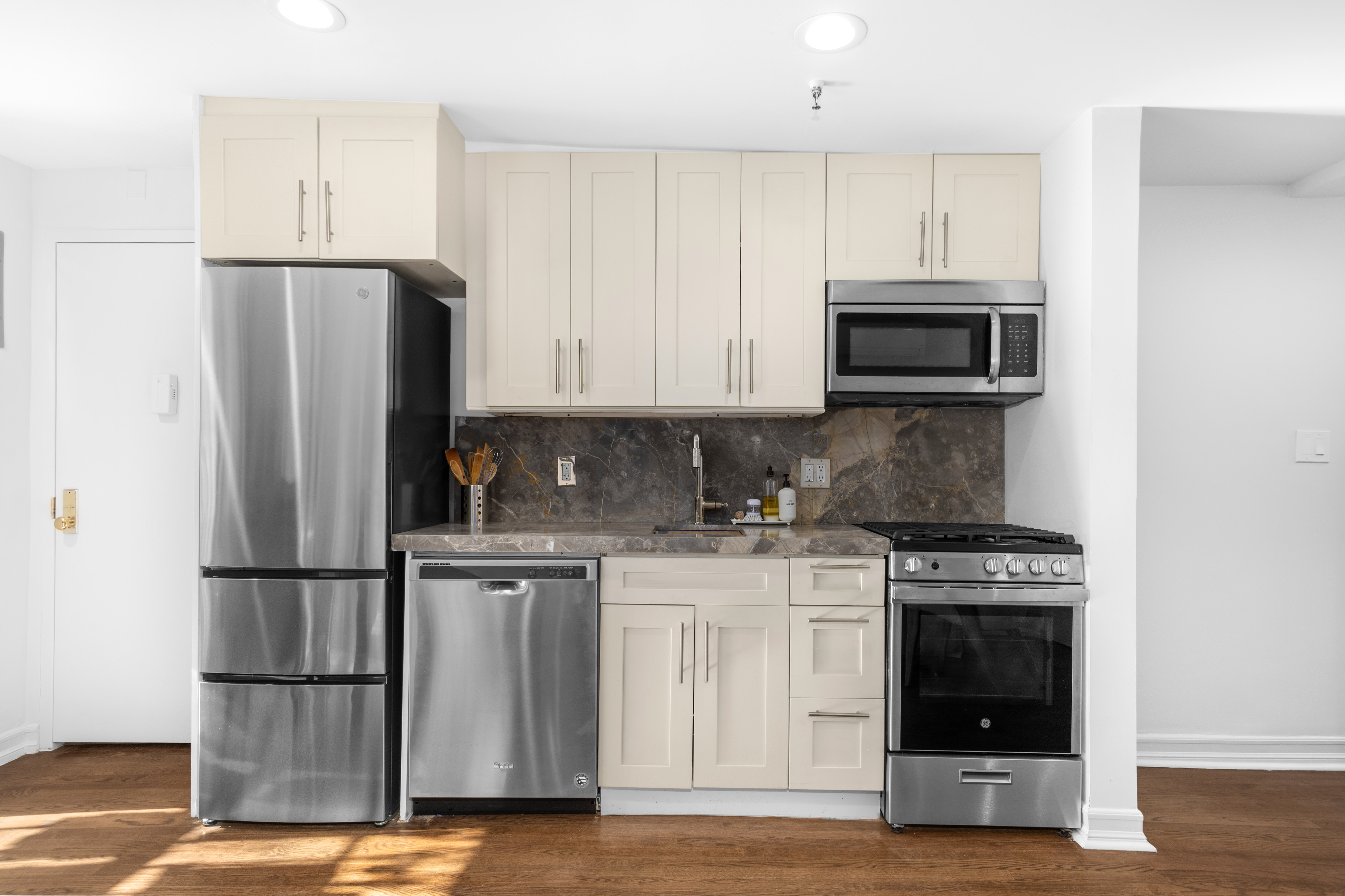 191 MacDonough Street, Unit 2 Brooklyn, NY 11216 - Photo 5 of 7 a kitchen with stainless steel appliances granite countertop a stove a refrigerator and a microwave