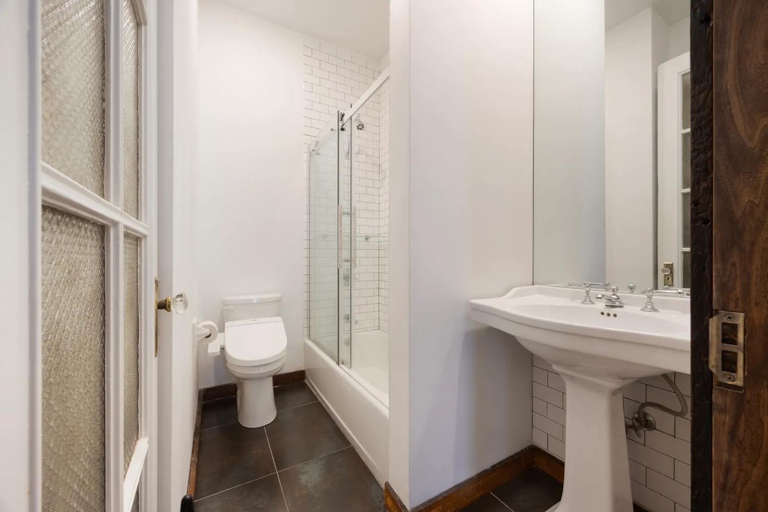 a bathroom with a toilet sink and a mirror