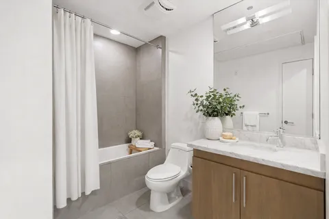 a bathroom with a sink a toilet a shower and a mirror
