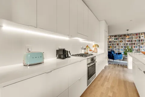 a kitchen with stainless steel appliances granite countertop a stove and a wooden floors