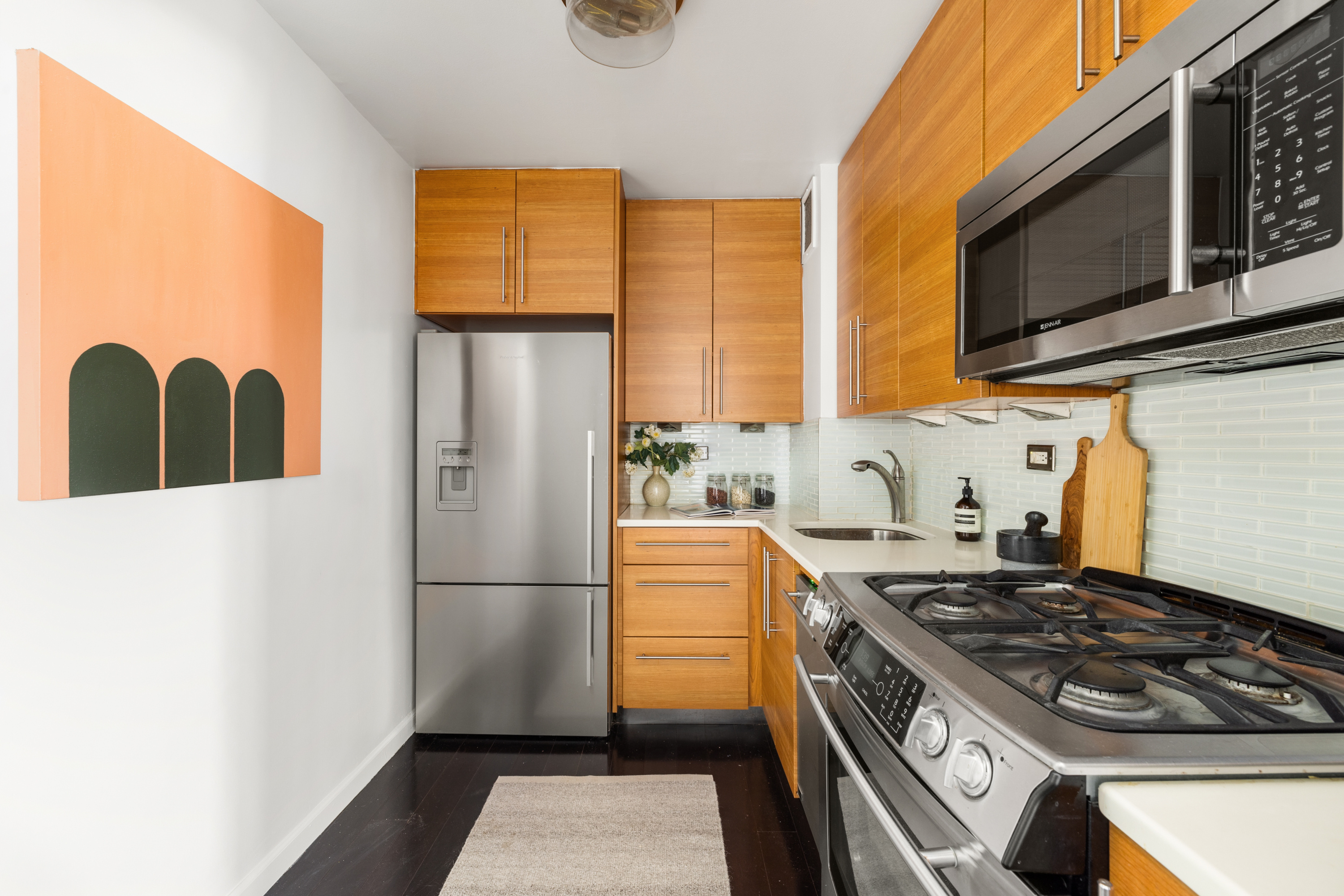 10 West 15th Street, Unit 1721 Manhattan, NY 10011 - Photo 4 of 10 a kitchen with stainless steel appliances granite countertop a stove a refrigerator and a microwave