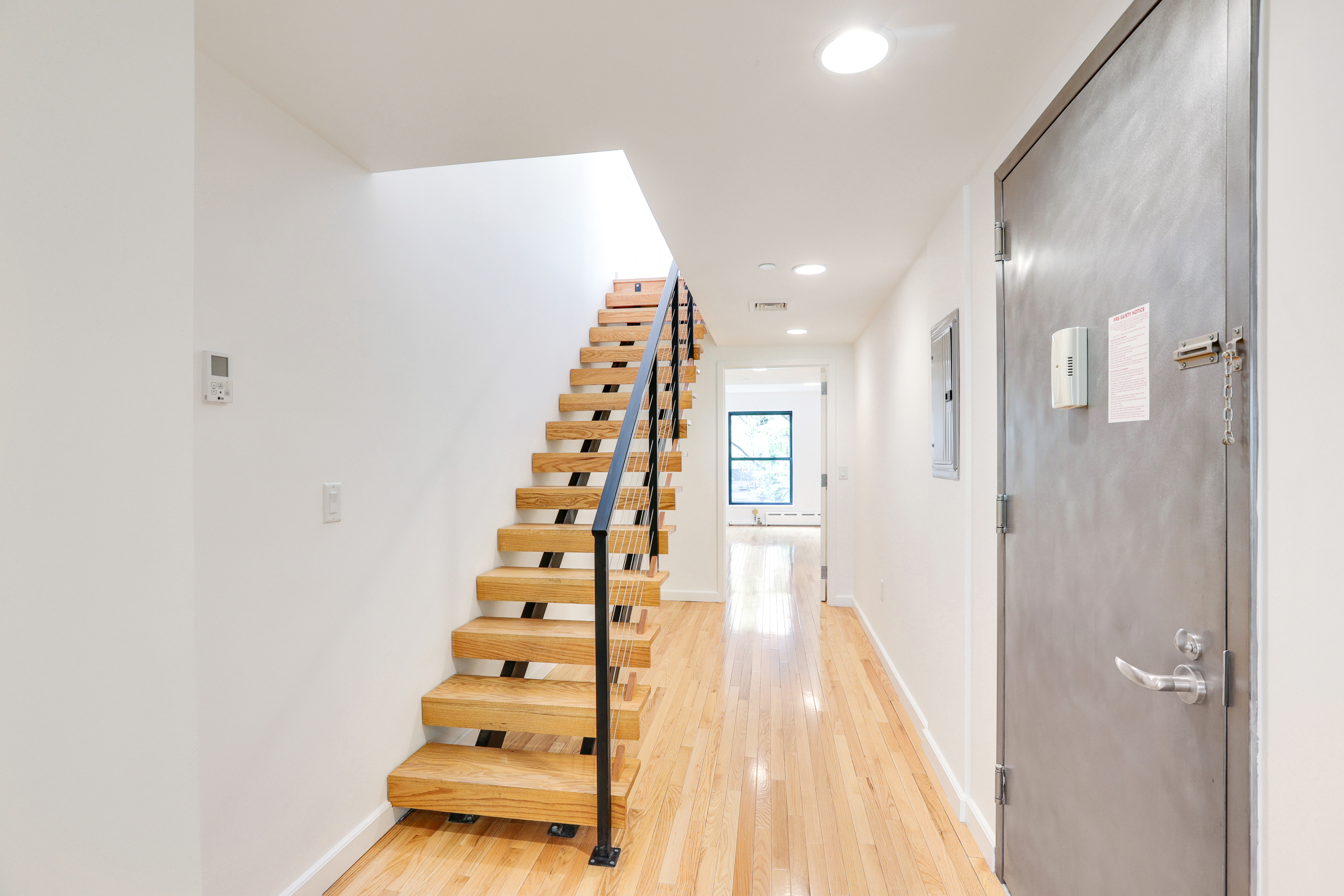 230 West 75th Street, Unit 4 Manhattan, NY 10023 - Photo 6 of 16 a view of a hallway with stairs and wooden floor