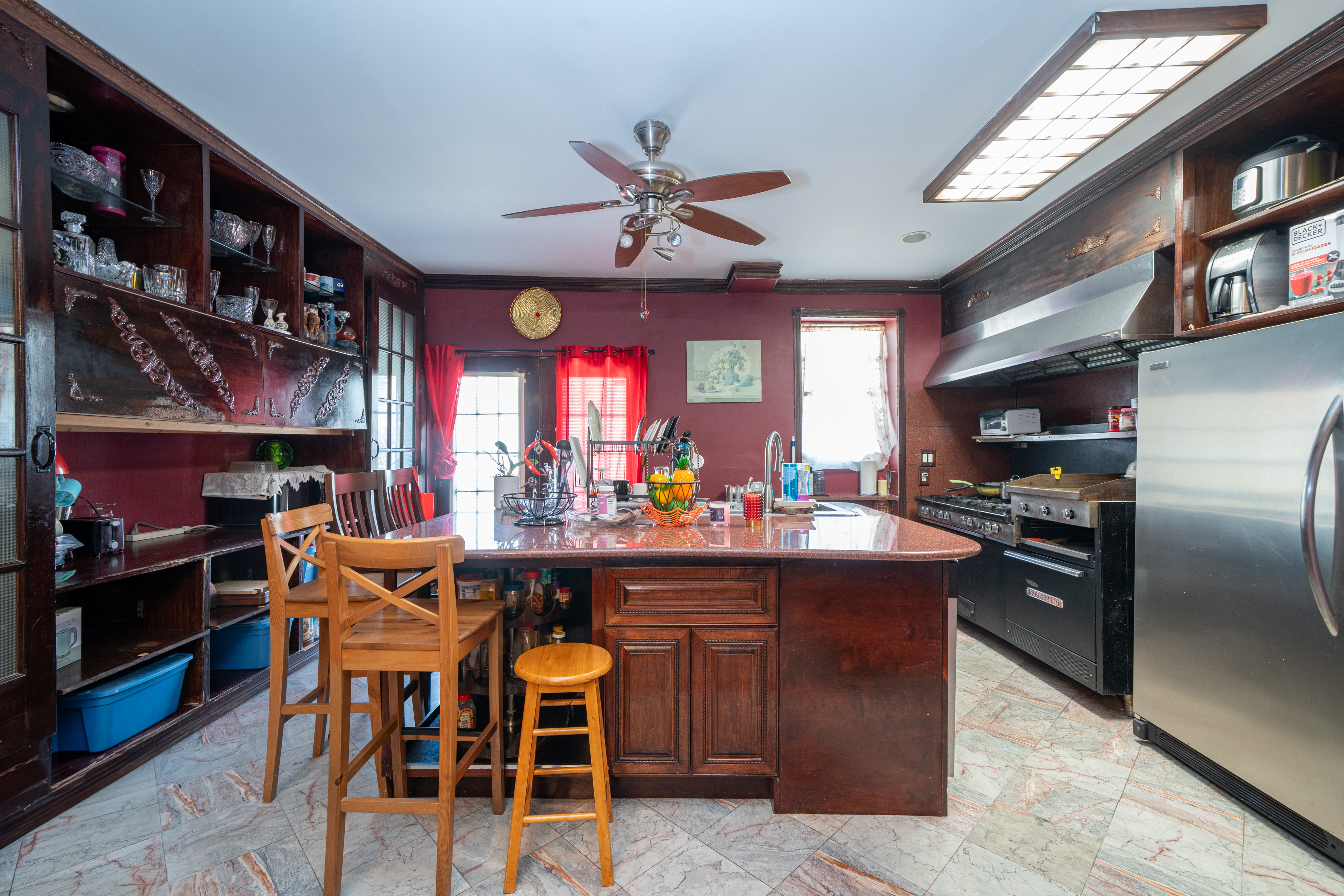 415 84th Street Brooklyn, NY 11209 - Photo 6 of 17 a kitchen with stainless steel appliances kitchen island granite countertop a table chairs and a refrigerator