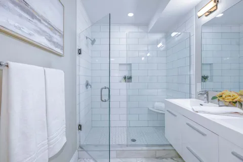 a bathroom with a sink shower and a mirror