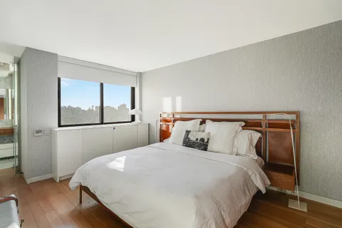 a bedroom with a large bed and wooden floor