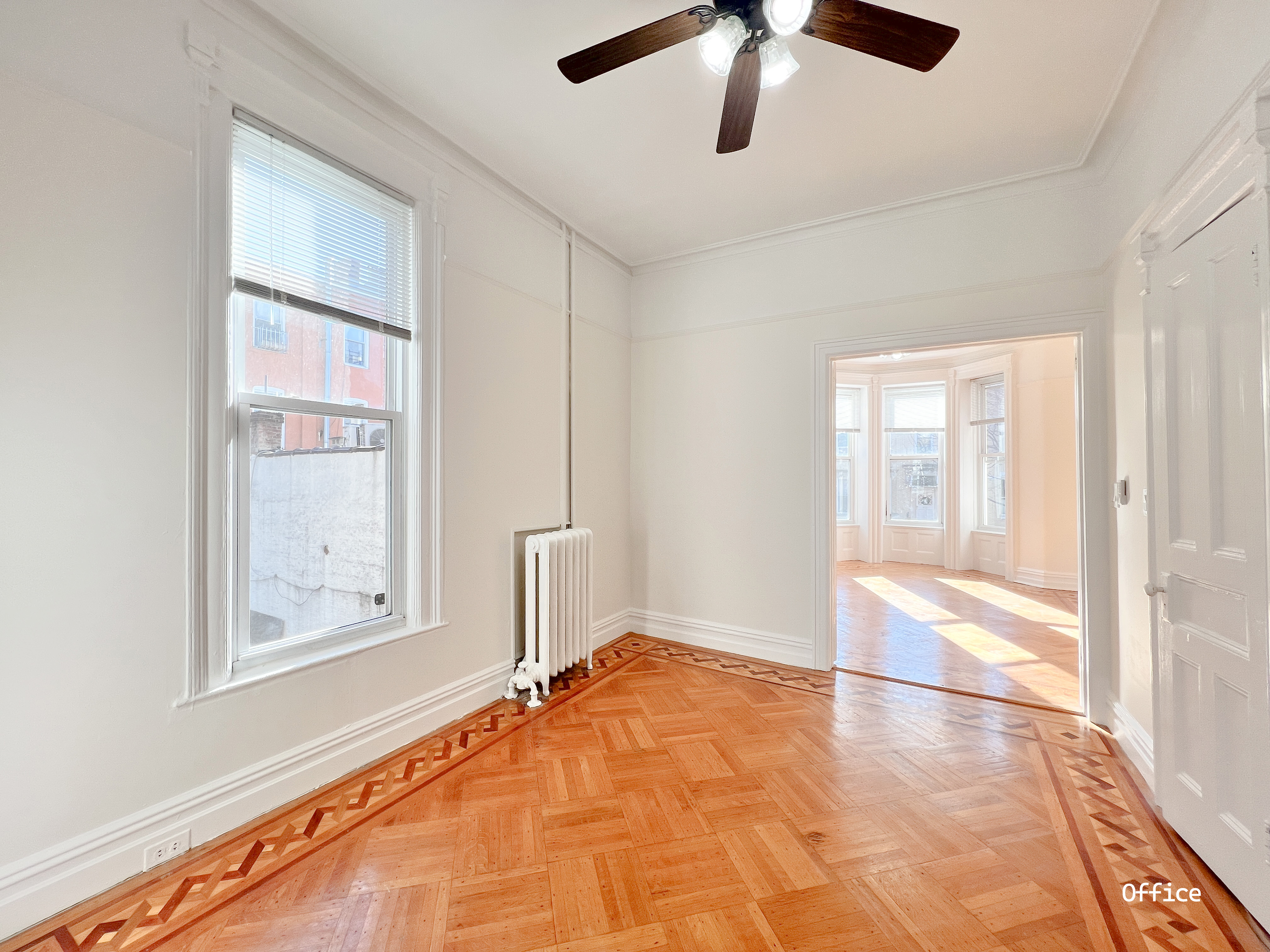 271 71st Street, Unit 2 Brooklyn, NY 11209 - Photo 6 of 10 a view of an empty room with chandelier fan and fire place