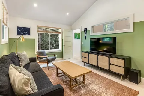 a living room with furniture a flat screen tv and a window