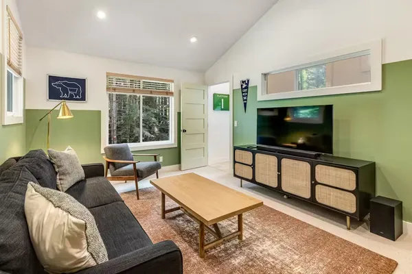 a living room with furniture a flat screen tv and a window