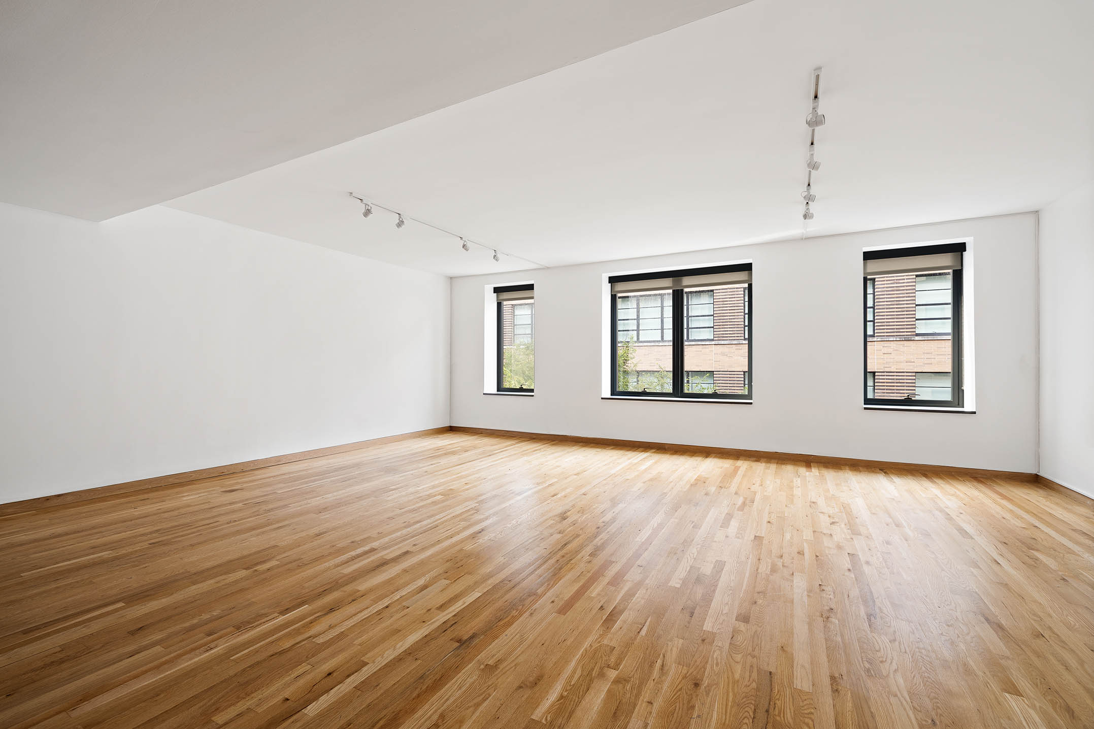 75 Sullivan Street, Unit 5S Manhattan, NY 10012 - Photo 8 of 12 an empty room with wooden floor and windows