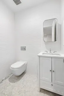 a bathroom with a toilet sink and mirror