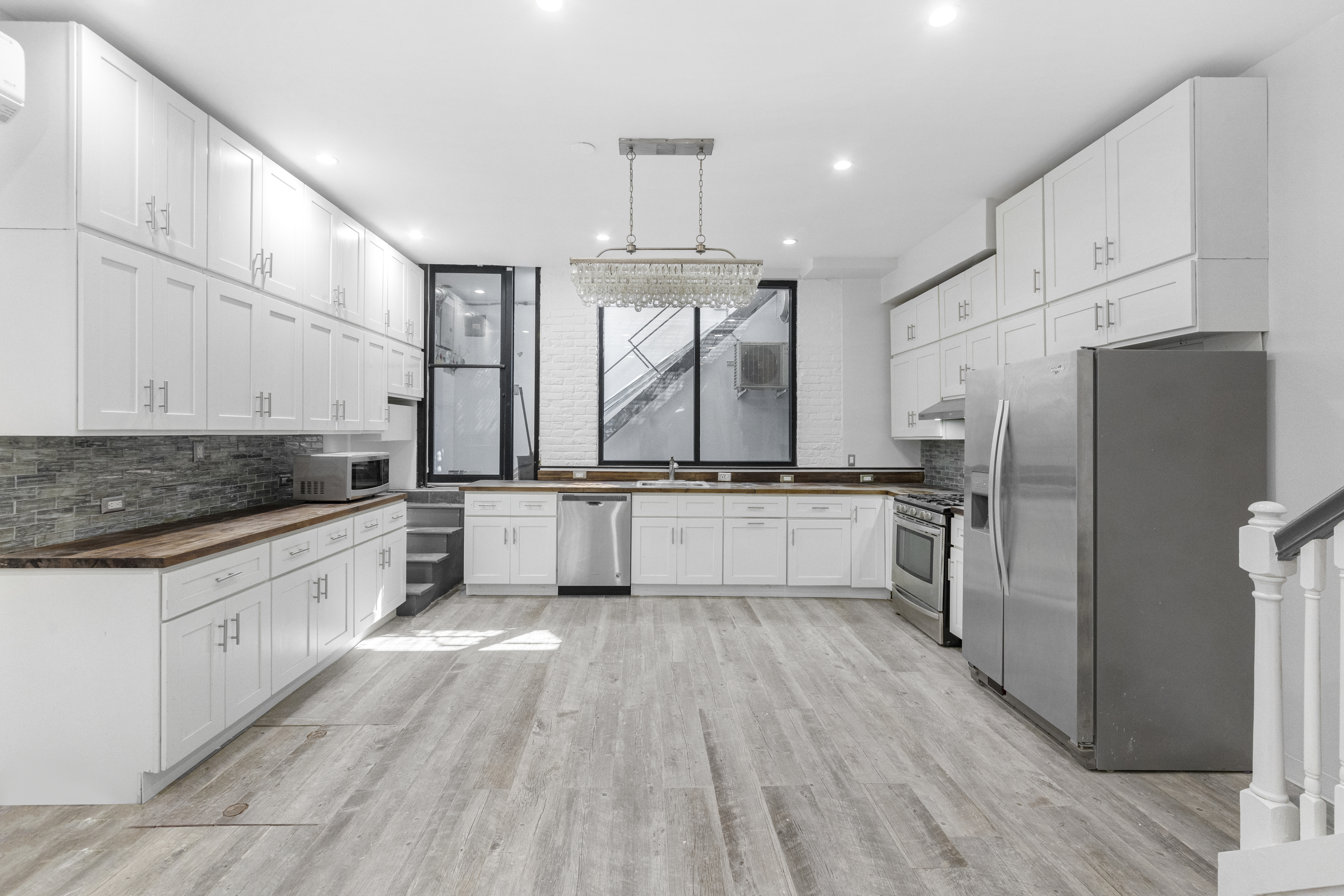 1061 Fulton Street, Unit 1 Brooklyn, NY 11238 - Photo 2 of 13 a large kitchen with cabinets wooden floor and stainless steel appliances
