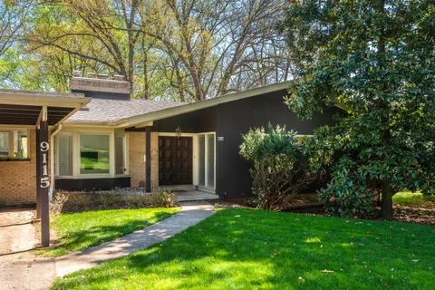 a view of a house with backyard and a tree