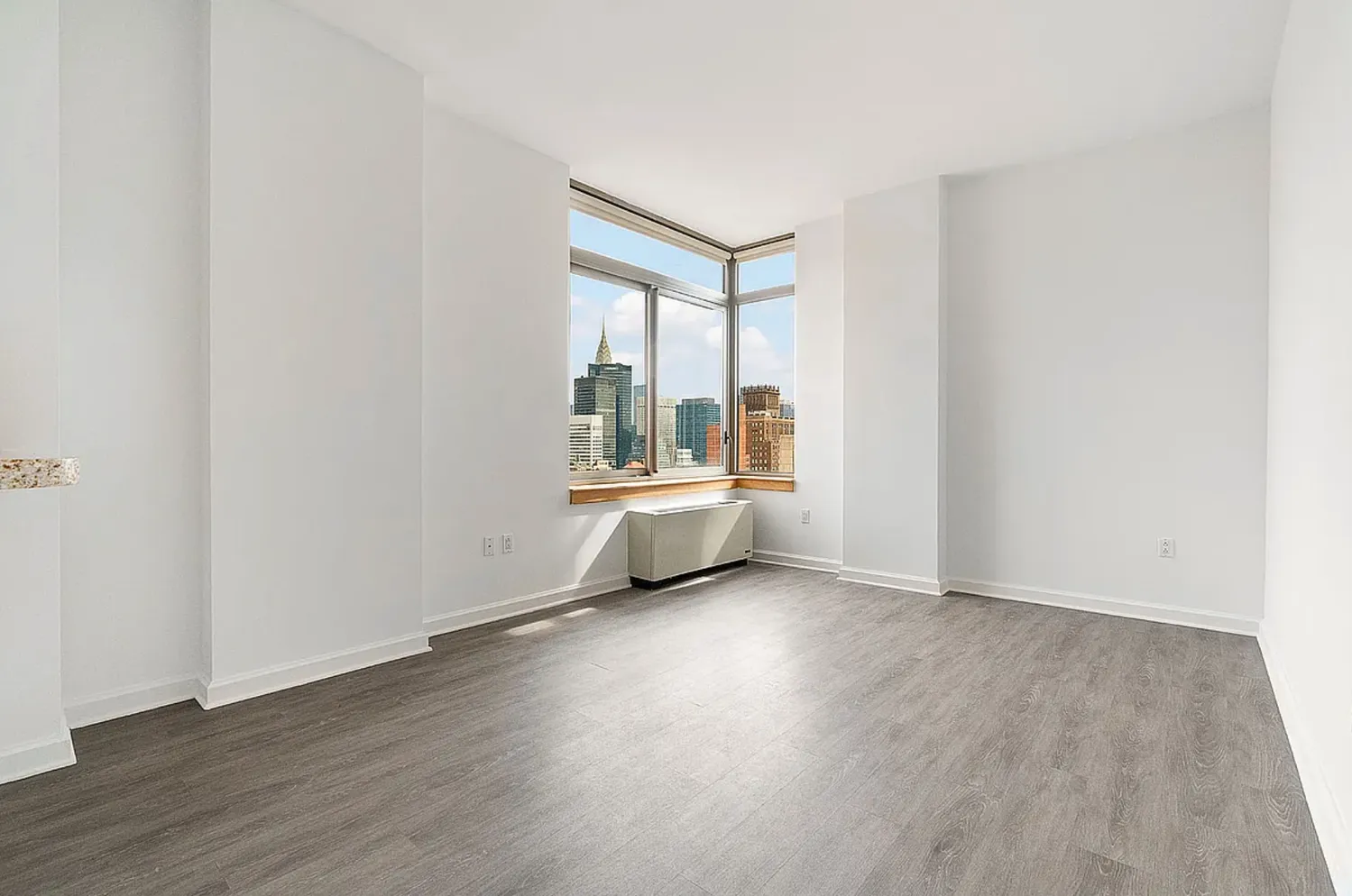 a view of a room with wooden floor and windows