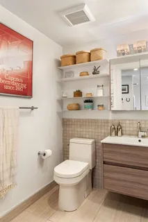 a bathroom with a toilet a sink and mirror