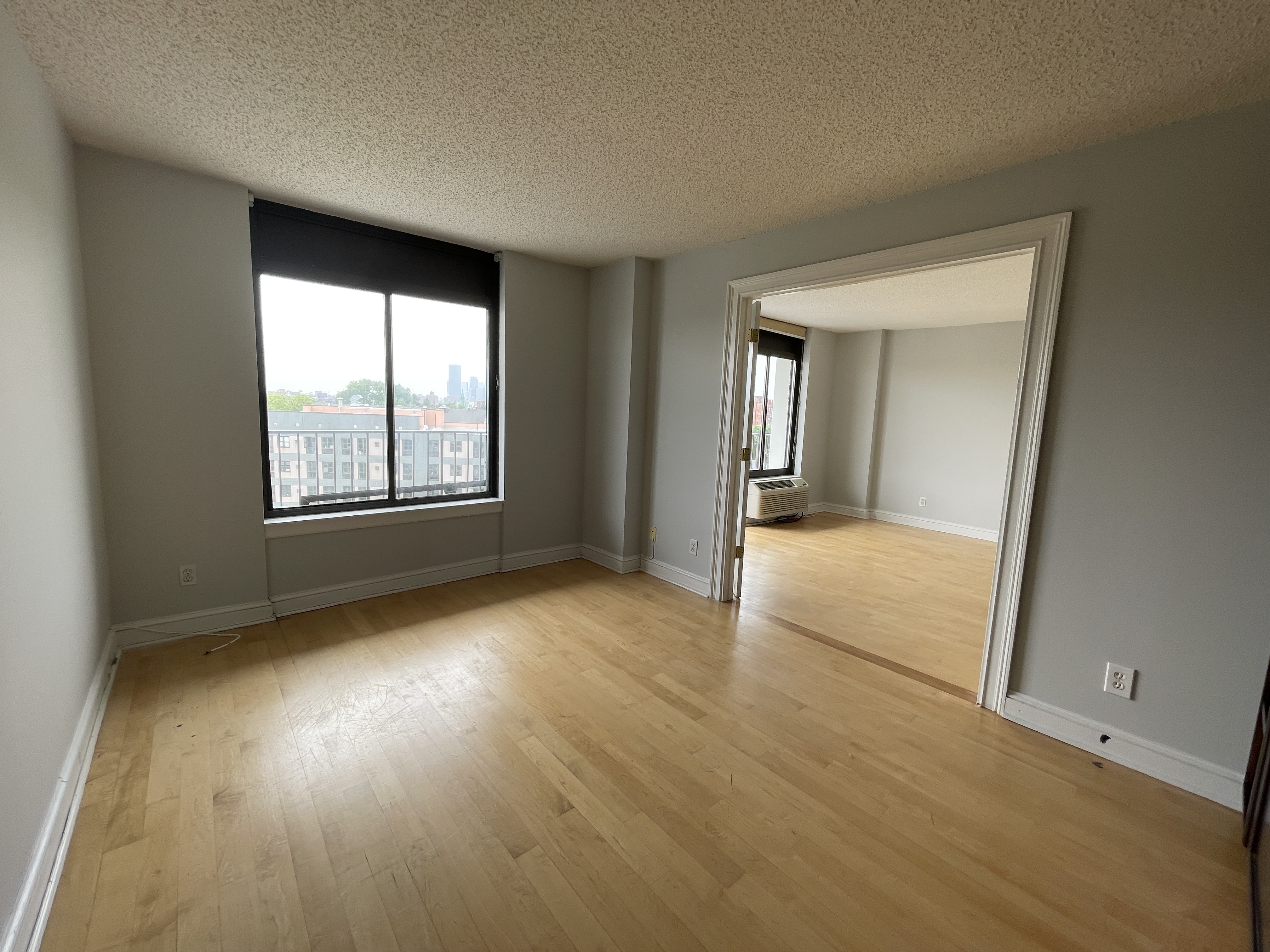 25-40 Shore Boulevard, Unit 8G Queens, NY 11102 - Photo 12 of 25 an empty room with wooden floor and windows