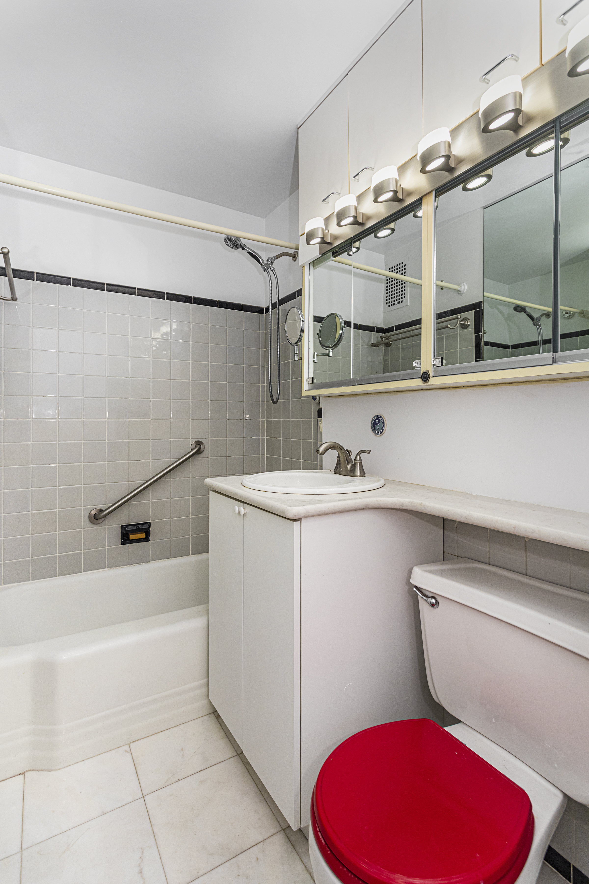 221 East 50th Street, Unit 8A Manhattan, NY 10022 - Photo 6 of 8 a bathroom with a sink mirror vanity and toilet