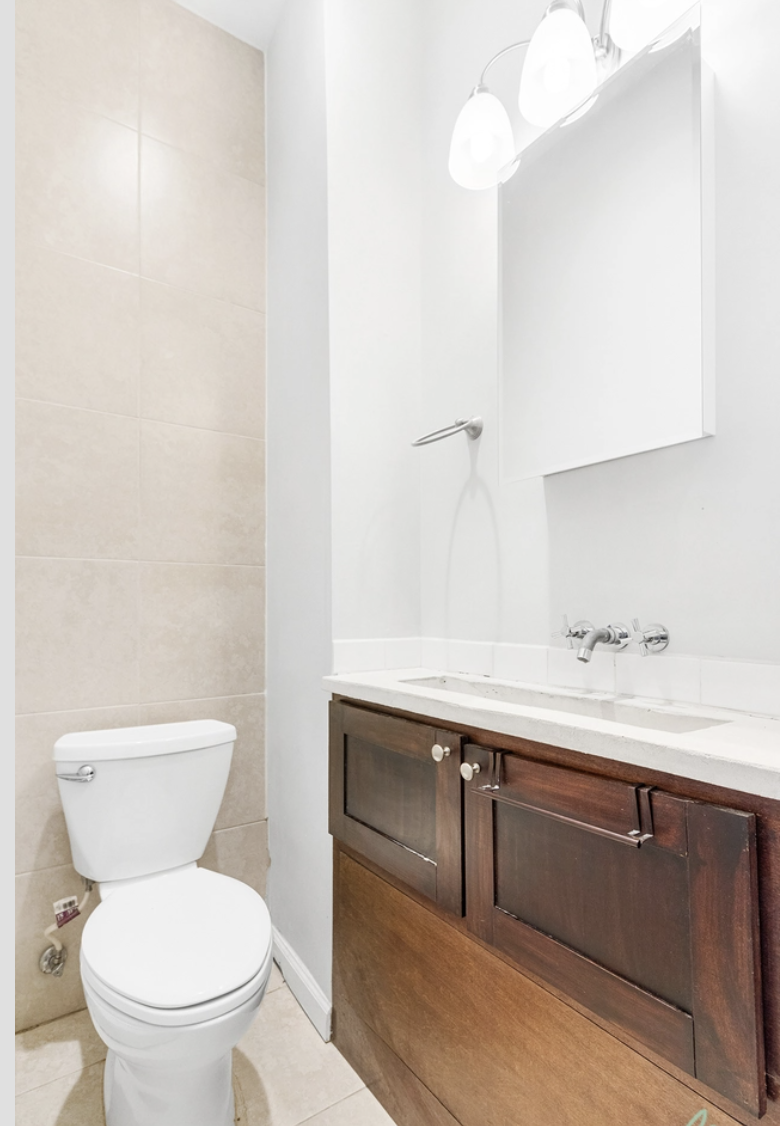 22-18 41st Street, Unit 2R Queens, NY 11105 - Photo 10 of 10 a bathroom with a toilet sink and mirror