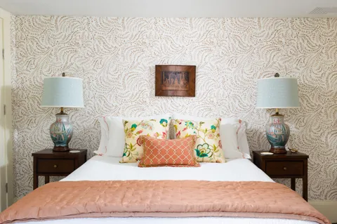 a bedroom with a bed and a lamp on dresser