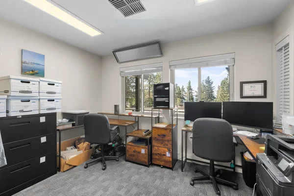 a view of a workspace with furniture and a window