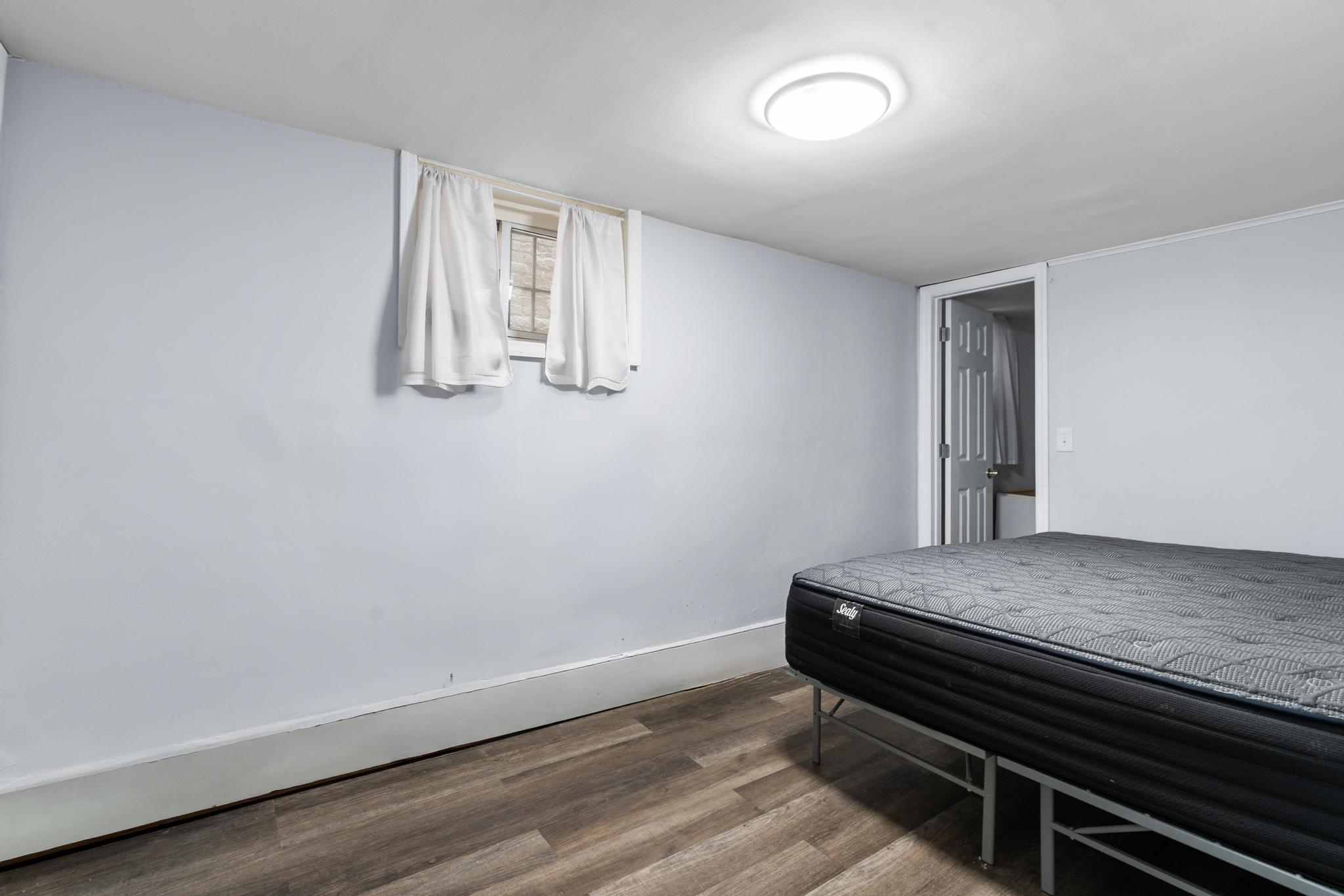 4513 Snyder Avenue Brooklyn, NY 11203 - Photo 9 of 13 a hallway with a bed and wooden floor