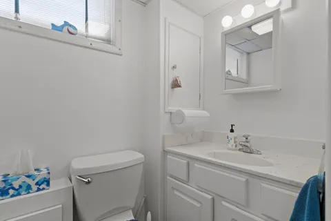 a bathroom with a sink toilet and a mirror