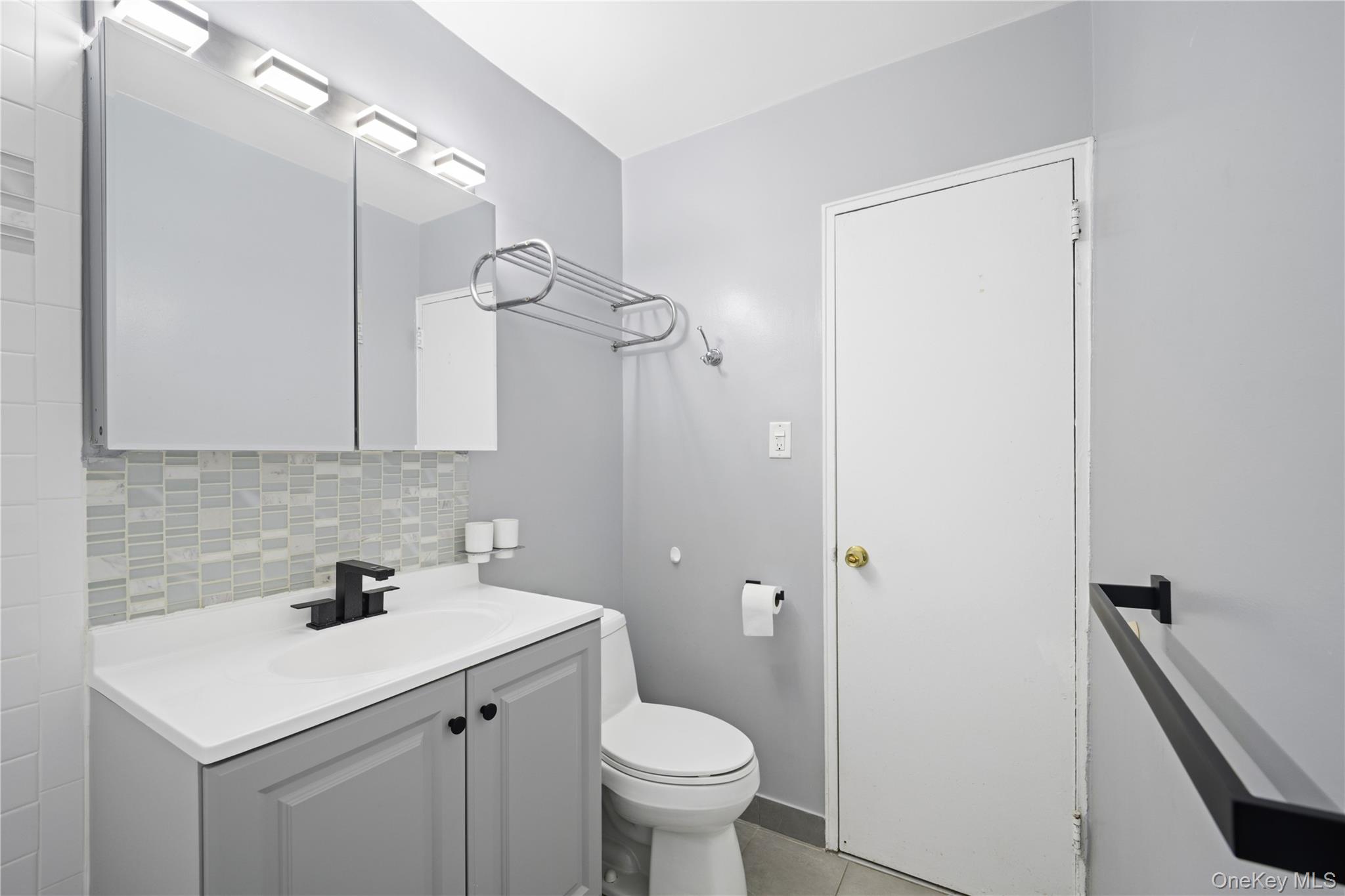 75-34 Bell Boulevard, Unit LD Queens, NY 11364 - Photo 14 of 26 a bathroom with a toilet sink and mirror