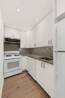 a kitchen with granite countertop a sink stove and refrigerator